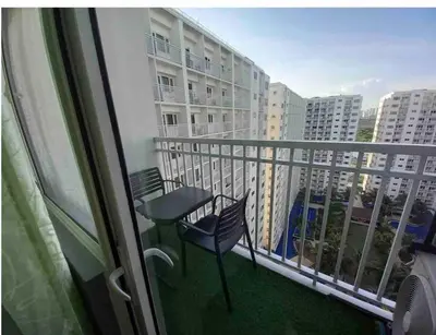 a balcony with a table and a chair on a balcony at Sithonia Suite, Shore Residences Tower C near MOA in Manila