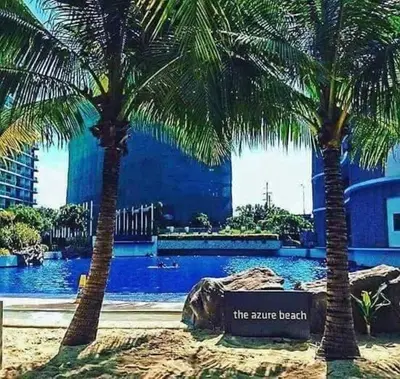 two palm trees in front of a swimming pool at AZURE C1 with balcony wifi MULTIPLE UNITS near airport in Manila