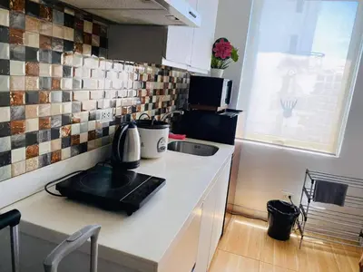 a small kitchen with a sink and a microwave at AZURE C1 with balcony wifi MULTIPLE UNITS near airport in Manila