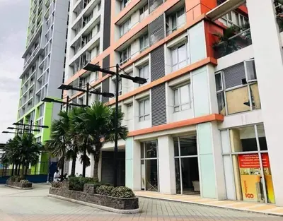 a tall building with palm trees in front of it at U607 Sunshine100 Netflix 65InchesTV Wifi Karaoke Swimming Pool in Manila