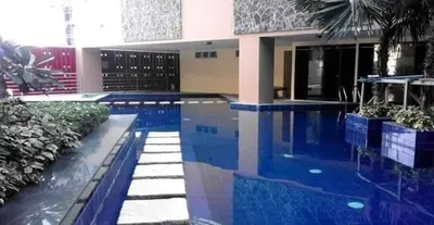 a house with a swimming pool in front of a building at U607 Sunshine100 Netflix 65InchesTV Wifi Karaoke Swimming Pool in Manila