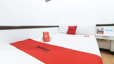 a room with a bed with a red blanket on it at RedDoorz Plus at Villa Gloria Taguig in Manila
