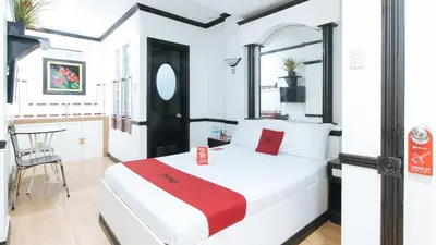 a bedroom with a bed and a table and a chair at RedDoorz Plus at Villa Gloria Taguig in Manila