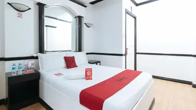 a bedroom with a large white bed with a window at RedDoorz Plus at Villa Gloria Taguig in Manila