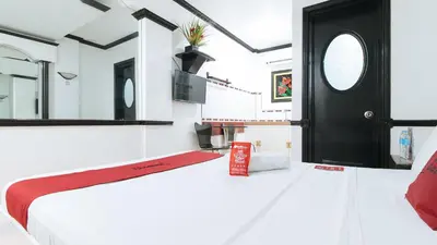 a bedroom with a bed and a black door at RedDoorz Plus at Villa Gloria Taguig in Manila