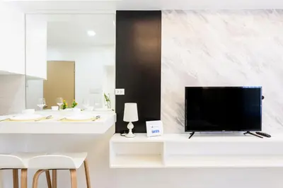a living room with a television on a white table at Elegant Living at Grace Residences T3-2206 Taguig-Steps from SM Aura and BGC in Manila