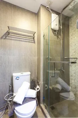 a bathroom with a toilet and a glass shower at Elegant Living at Grace Residences T3-2206 Taguig-Steps from SM Aura and BGC in Manila