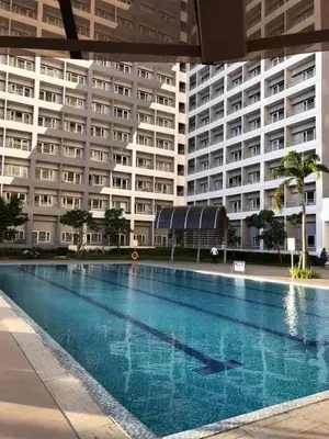 a swimming pool in front of a large building at Elegant Living at Grace Residences T3-2206 Taguig-Steps from SM Aura and BGC in Manila