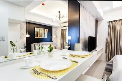 a room with a dining table with plates and utensils at Elegant Living at Grace Residences T3-2206 Taguig-Steps from SM Aura and BGC in Manila