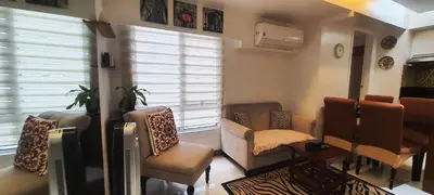 a living room with a bunch of chairs and a tv at BGC Fort Victoria in Manila