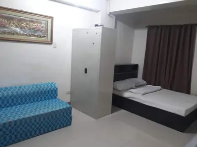 a room with two beds and a cabinet and a chair at Your City•Home Apartment in Manila