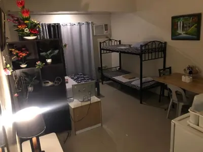 a small room with two bunk beds and a table at Your City•Home Apartment in Manila