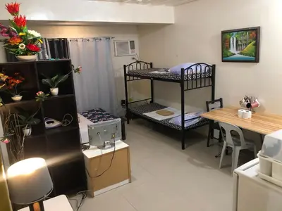 a room with two bunk beds and a table at Your City•Home Apartment in Manila