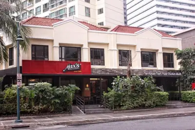a white building with a red sign on it at StayHere Burgos Circle 1 Bedroom Avant@Fort Gym in Manila