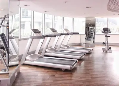 a gym with treadmills and elliptical machines at StayHere Burgos Circle 1 Bedroom Avant@Fort Gym in Manila