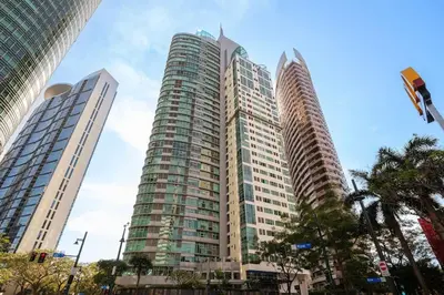 two tall buildings in a city with palm trees at StayHere Burgos Circle 1 Bedroom Avant@Fort Gym in Manila