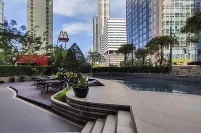 a courtyard with tables and chairs in a city at StayHere Burgos Circle 1 Bedroom Avant@Fort Gym in Manila