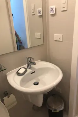 a bathroom with a white sink and a mirror at 1217 Urban Simplicity in Manila