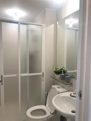 a bathroom with a shower and a toilet and a sink at 1217 Urban Simplicity in Manila