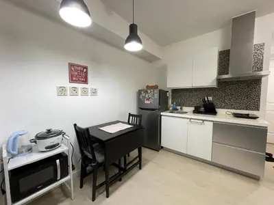 a kitchen with a small table and a black refrigerator at 1217 Urban Simplicity in Manila