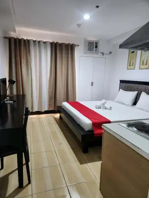 a bedroom with a bed with a red blanket at POBLACION SUITES - Polaris in Manila