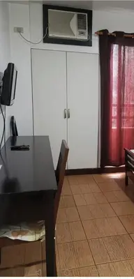 a dining room with a table and a air conditioner at POBLACION SUITES - Polaris in Manila