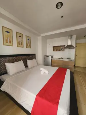 a bedroom with a large white bed with a red blanket at POBLACION SUITES - Polaris in Manila