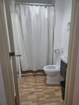 a bathroom with a toilet and a shower curtain at POBLACION SUITES - Polaris in Manila