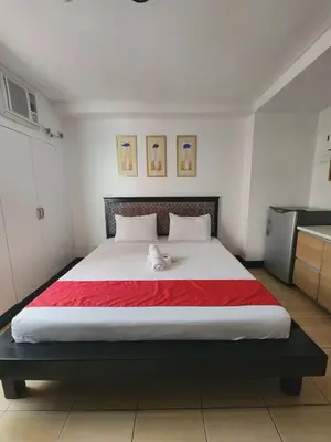 a bedroom with a large bed with a red blanket at POBLACION SUITES - Polaris in Manila