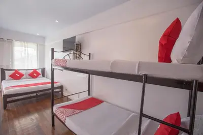 a room with two bunk beds with red and white pillows at OYO 588 Sunrock Resort in Antipolo