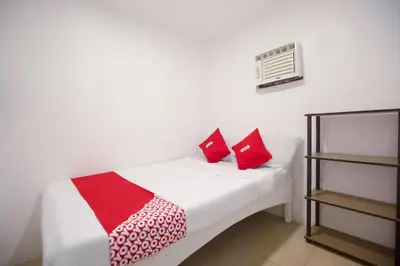 a bedroom with a bed with red pillows on it at OYO 588 Sunrock Resort in Antipolo