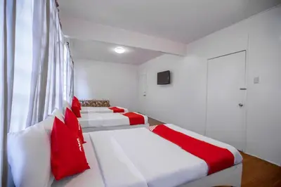 a room with three beds with red pillows at OYO 588 Sunrock Resort in Antipolo