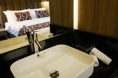 a bathroom with a sink and a bed in a room at UNWND Boutique Hotel Makati in Manila
