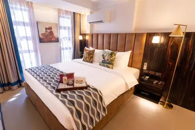 a bedroom with a large bed with a wooden headboard at UNWND Boutique Hotel Makati in Manila