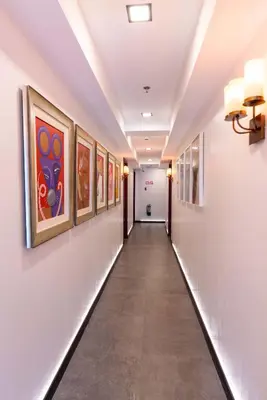 a long hallway with paintings on the walls at UNWND Boutique Hotel Makati in Manila