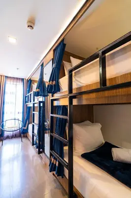 a room with three bunk beds in a dorm room at UNWND Boutique Hotel Makati in Manila
