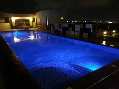 a large swimming pool at night with blue lights at Morgan Suite BGC shortwalk4 Venice Canal Mall free pool gym in Manila
