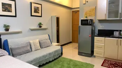 a living room with a couch and a refrigerator at Morgan Suite BGC shortwalk4 Venice Canal Mall free pool gym in Manila