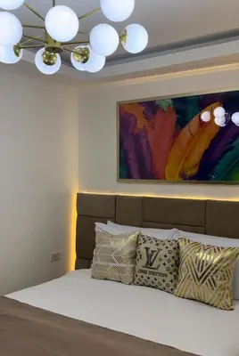 a bedroom with a bed with a painting on the wall at MAKATI Isabela Luxury in Manila