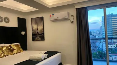 a bedroom with a bed and a window and a air conditioner at MAKATI Isabela Luxury in Manila