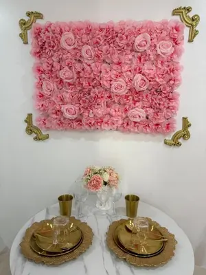 a table with two plates and a pink rose wall at MAKATI Isabela Luxury in Manila