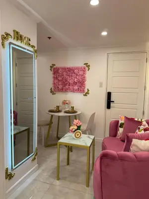 a living room with a pink couch and a table at MAKATI Isabela Luxury in Manila