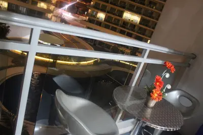 a table and chairs on a balcony with a view of a city at Azure Urban Resort Residence a4 near airport mall with wavepool in Manila