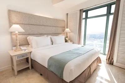a bedroom with a large bed with a large window at Vivere Hotel and Resorts in Manila