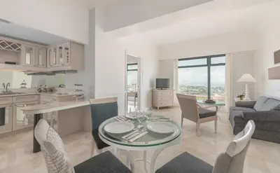 a kitchen and living room with a table and chairs at Vivere Hotel and Resorts in Manila