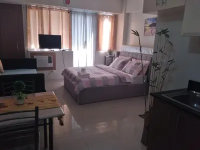 a living room with a bed and a couch at One Palm Tree Villas-Terminal 3 Pasay Manila in Manila