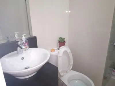 a bathroom with a white toilet and a sink at One Palm Tree Villas-Terminal 3 Pasay Manila in Manila