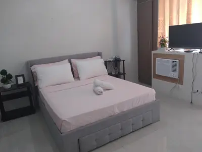 a bedroom with a large bed with a television on it at One Palm Tree Villas-Terminal 3 Pasay Manila in Manila