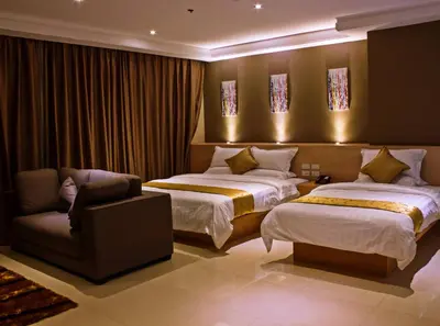 a hotel room with two beds and a chair at Dela Chambre Hotel in Manila