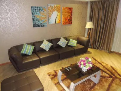 a living room with a brown leather couch and a table at Dela Chambre Hotel in Manila